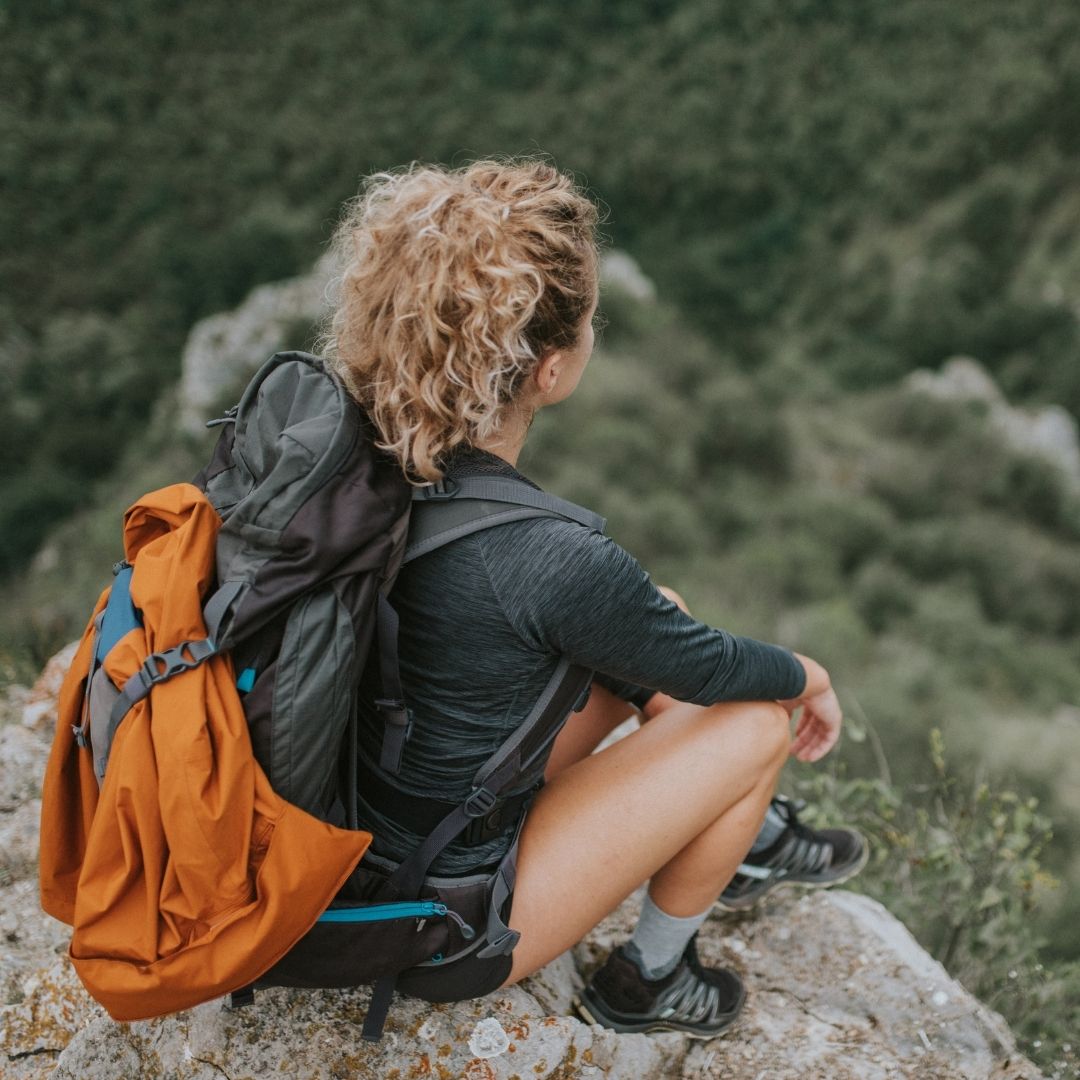 Woman sitting on a rock while out hiking
